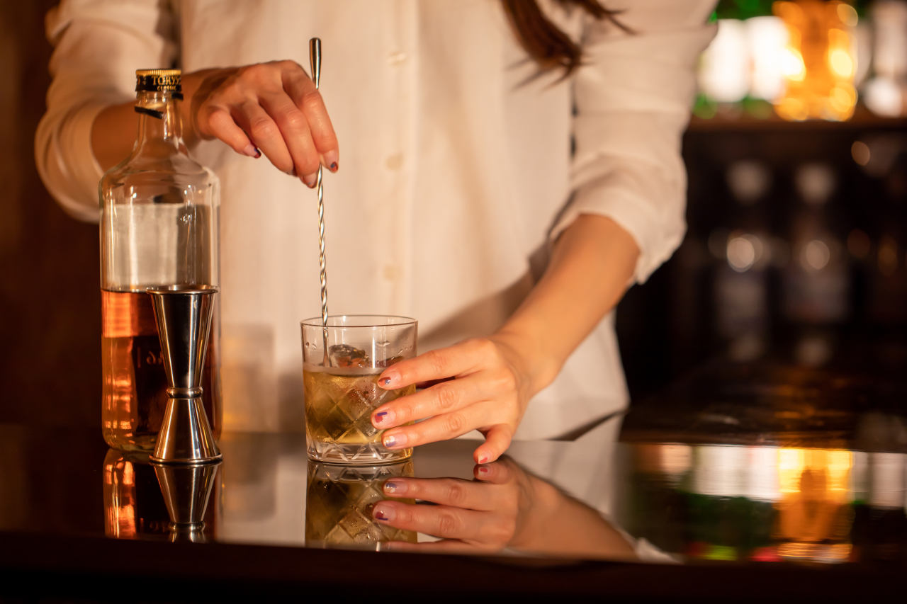 バーカウンターでドリンクを作る女性